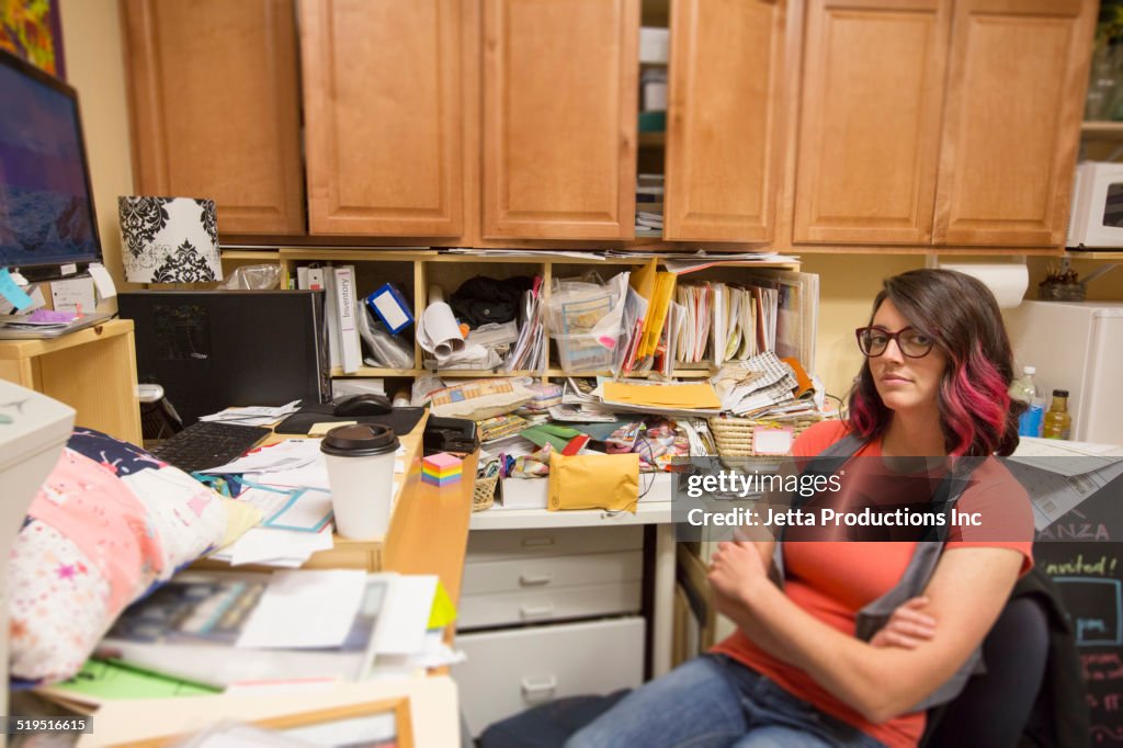 Caucasian woman sitting in messy office