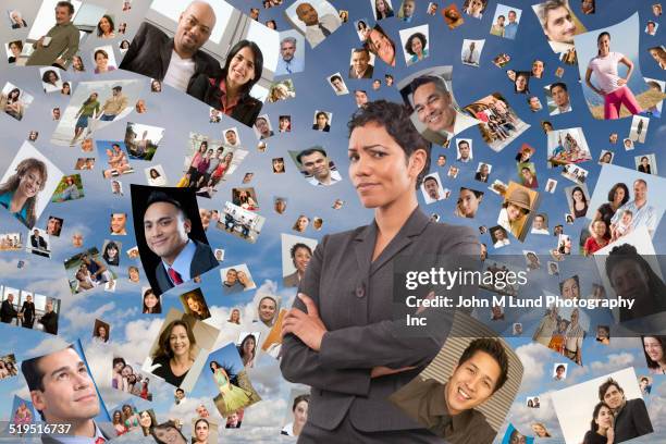 businesswoman standing in images of faces floating in sky - crowd looking into camera happy indian stock-fotos und bilder