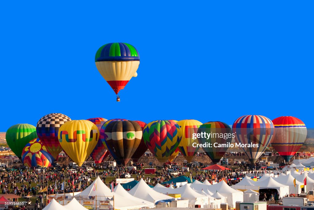 Hot air balloon floating above others at festival, Albuquerque, New Mexico, United States