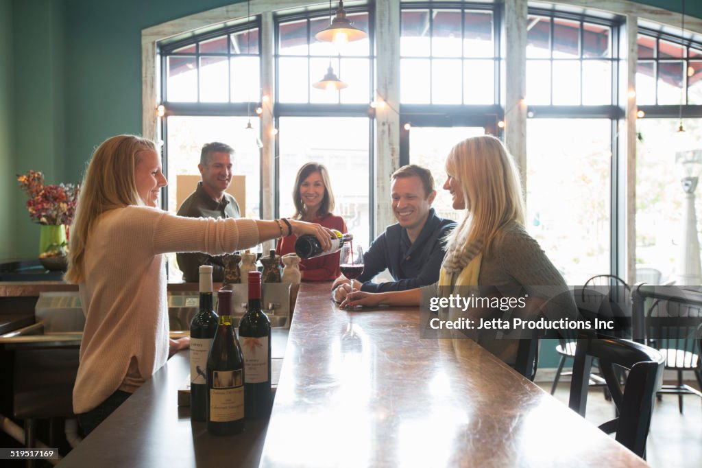 Bartender pouring wine at bar