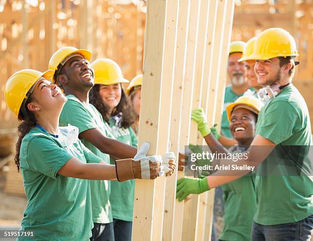 volunteers holding wood frame together - youth foundation stock pictures, royalty-free photos & images