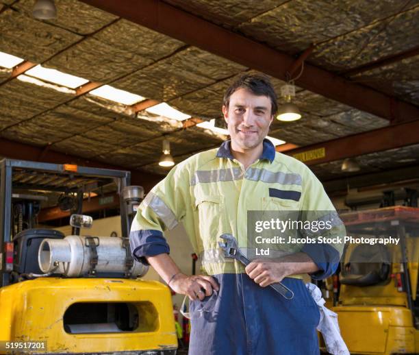 hispanic mechanic smiling in warehouse - australian worker photos et images de collection