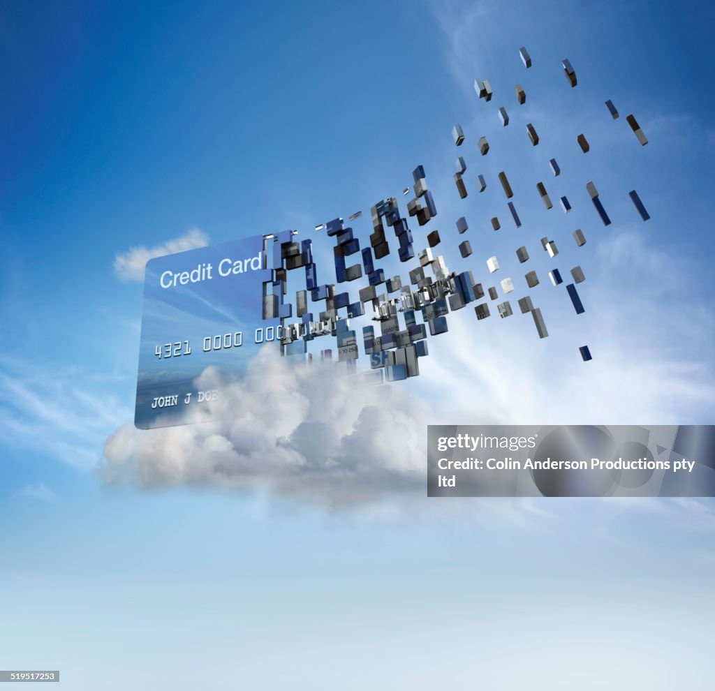 Credit card disintegrating into cloud in blue sky