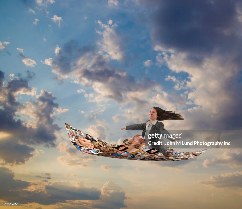 Businesswoman flying on carpet of images of smiling faces