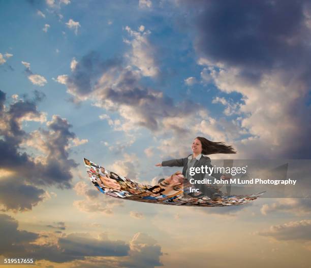 businesswoman flying on carpet of images of smiling faces - 空飛ぶ絨毯 ストックフォトと画像