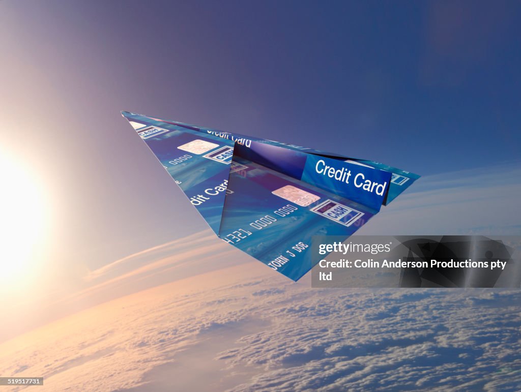 Credit card folded into paper airplane in atmosphere