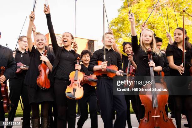 young musicians cheering with instruments - girl cello stock pictures, royalty-free photos & images