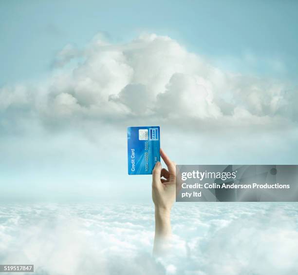 caucasian man holding credit card in clouds - crecimiento estirón fotografías e imágenes de stock