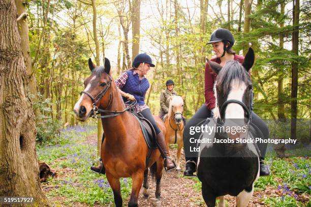 horseback riders talking in forest - andare a cavallo foto e immagini stock