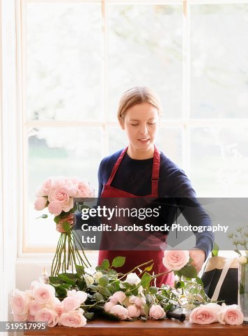 Caucasian florist arranging roses Caucasian florist arranging roses