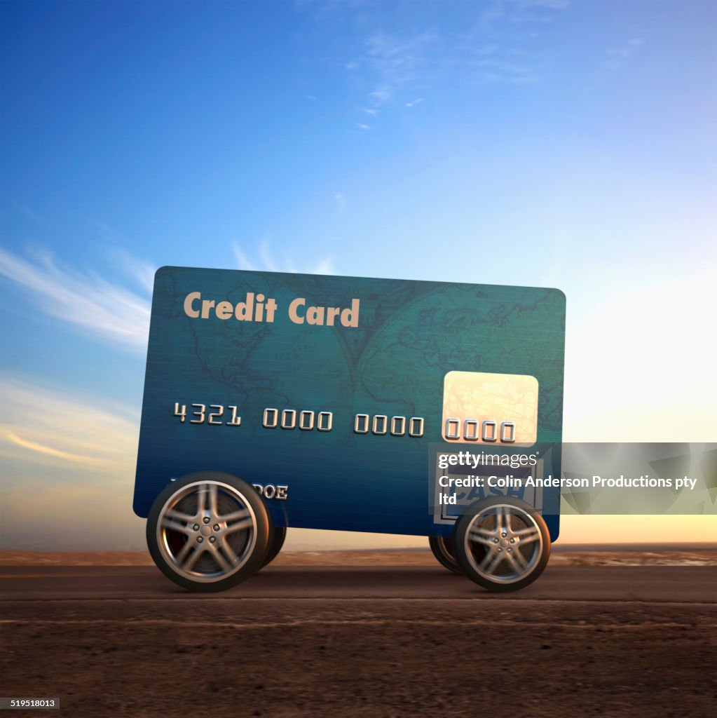 Car made out of credit card driving on remote road