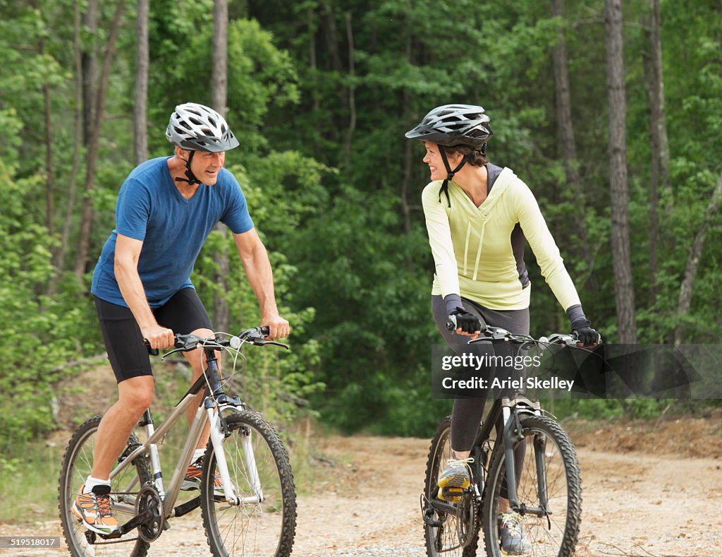 Caucasian couple riding mountain bikes together