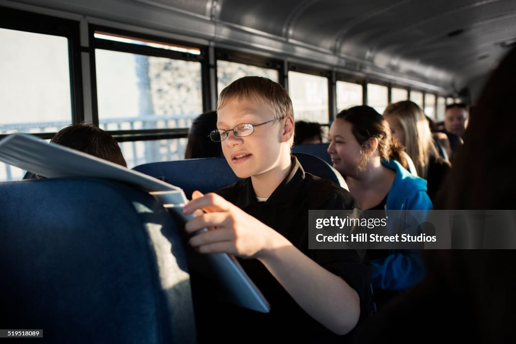 Young boy reading on school bus