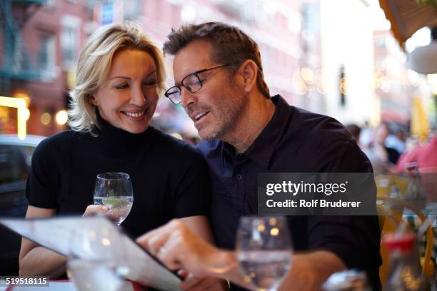 caucasian couple reading menu at urban cafe, new york city, new york, united states - i love new york foto e immagini stock