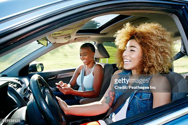 daughter driving mother in car - auto freunde stock-fotos und bilder