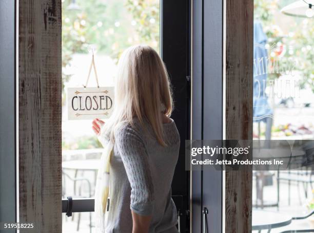 caucasian woman turning sign in shop window - store closing stock pictures, royalty-free photos & images