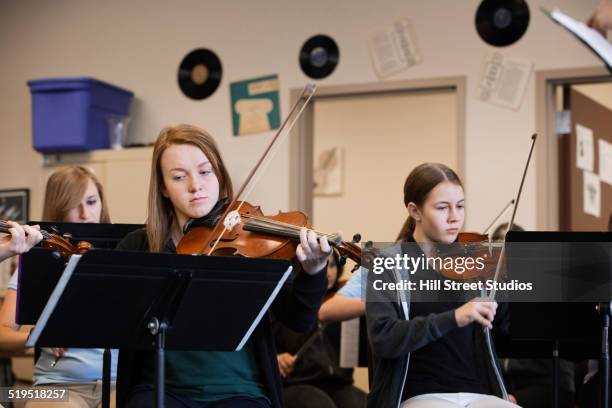 caucasian girls playing violin in music class - orchestra rehearsal stock pictures, royalty-free photos & images