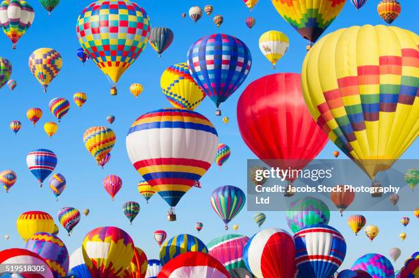 hot air balloons floating in blue sky - balloons in sky stock pictures, royalty-free photos & images