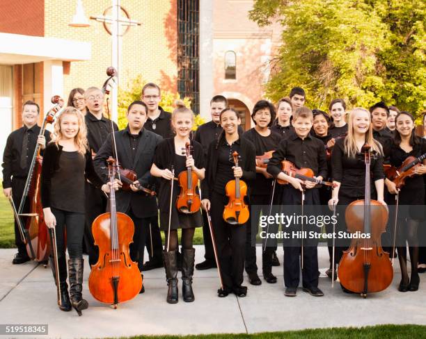 young musicians smiling with instruments - orchestra outside stock pictures, royalty-free photos & images