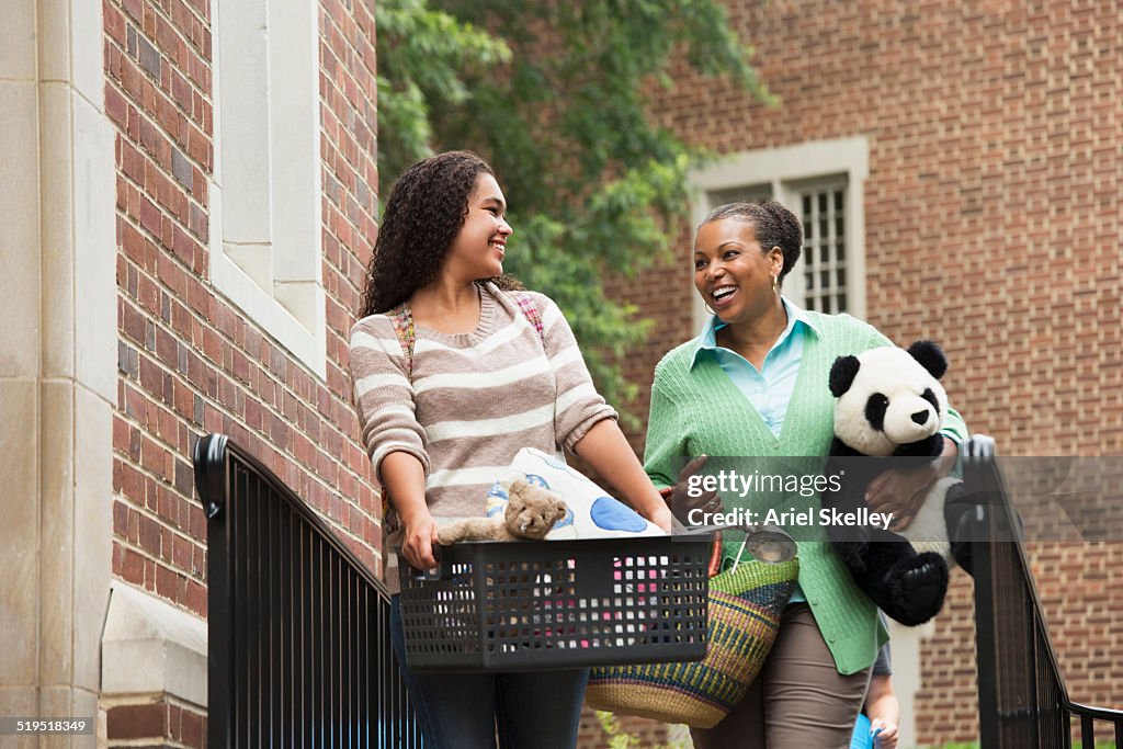 Mother helping daughter move into dormitory