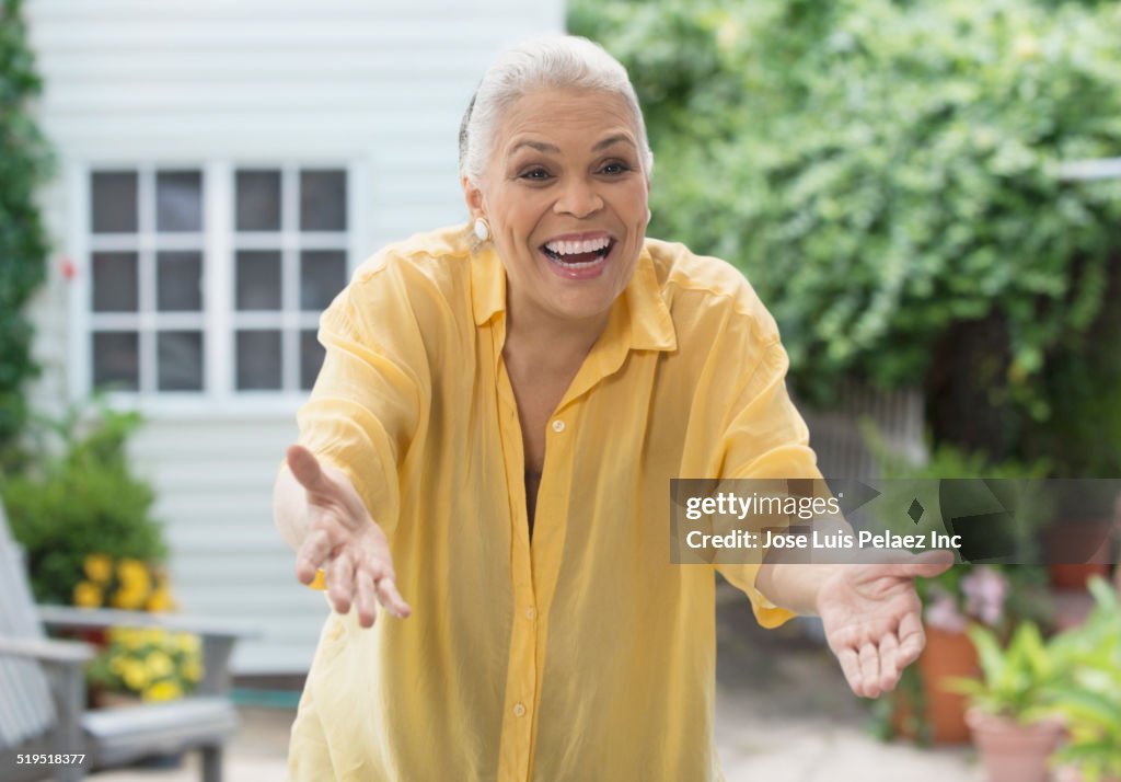 Older mixed race woman gesturing greeting