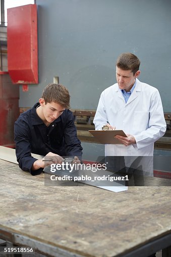 Supervisor assessing apprentice working Supervisor assessing apprentice working