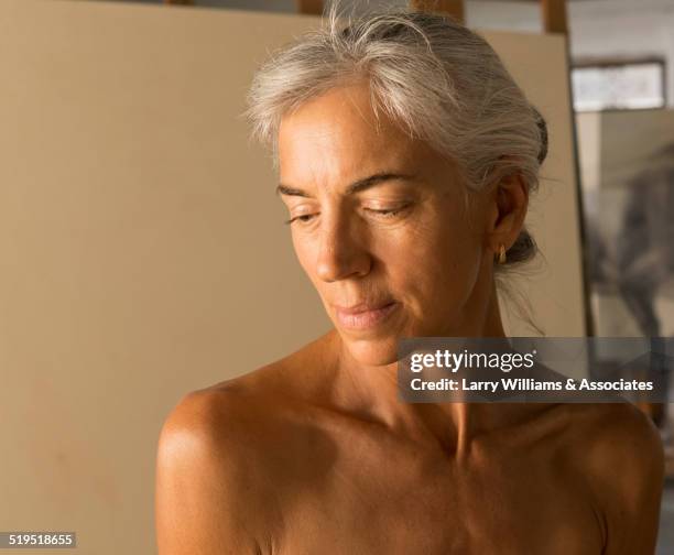 nude older caucasian woman modeling for artist in studio - artists model stock-fotos und bilder