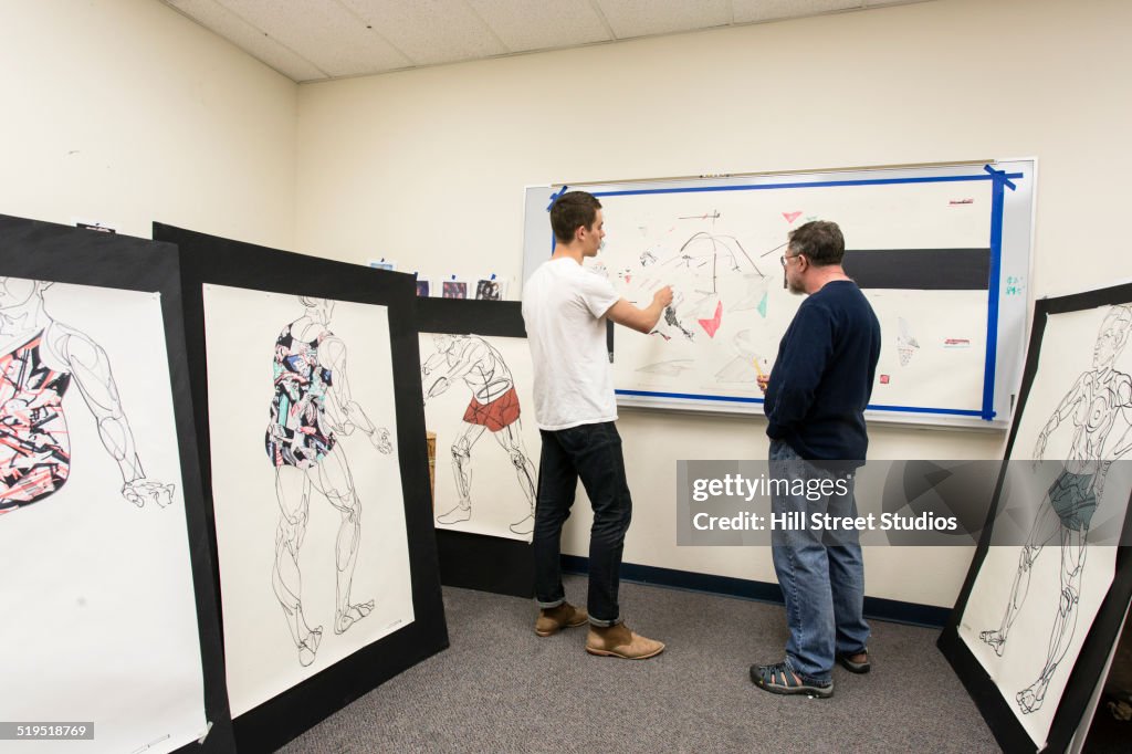 Caucasian artist teaching student in studio