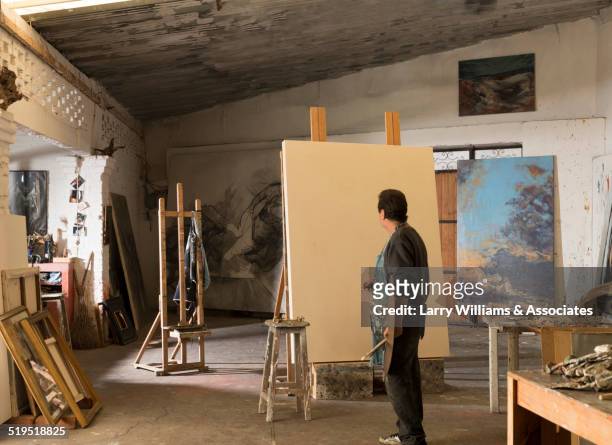 hispanic artist painting in studio - artist's canvas 個照片及圖片檔