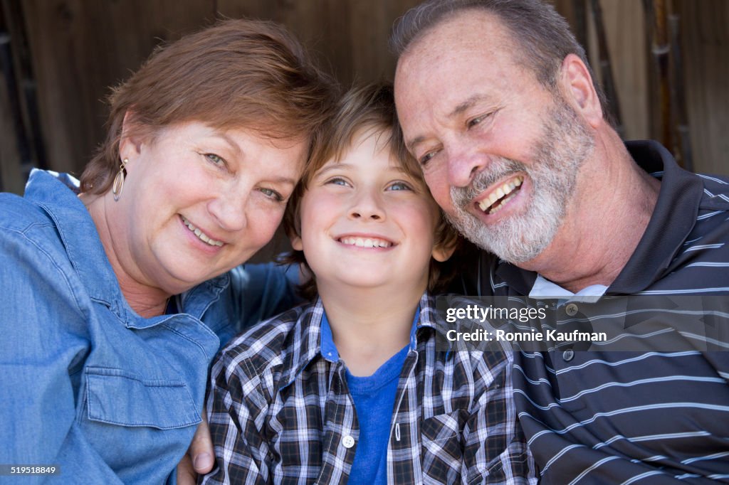 Older Caucasian couple relaxing with grandson outdoors