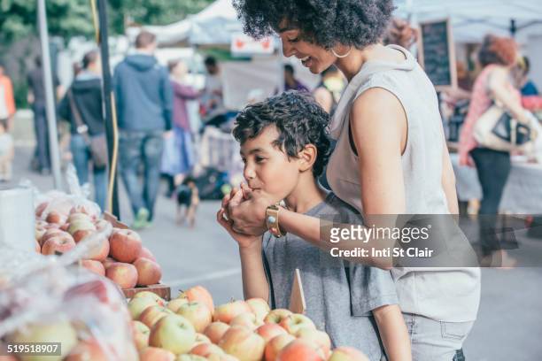 mixed race boy shopping with mother at farmers market - seattle market stock pictures, royalty-free photos & images