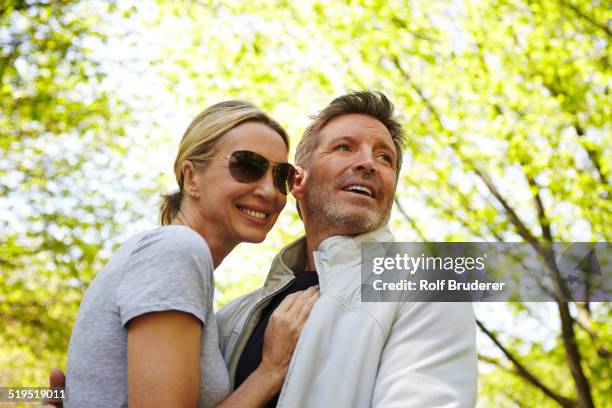 caucasian couple hugging in park - couple central park stockfoto's en -beelden