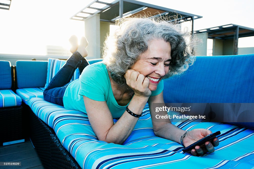 Caucasian woman using cell phone on urban rooftop