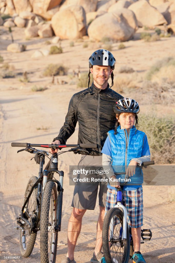 Caucasian father and son riding bicycles in desert landscape