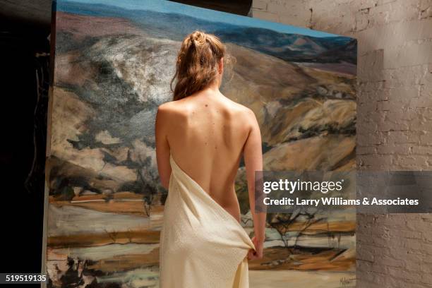 nude woman admiring painting in art gallery - artists model stock photos et images de collection