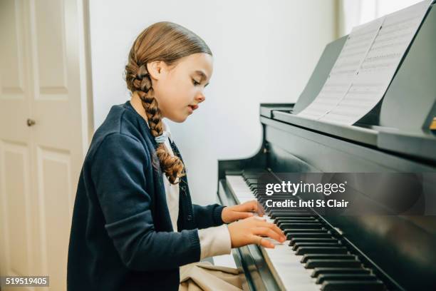 mixed race girl playing piano - practicing piano stock pictures, royalty-free photos & images