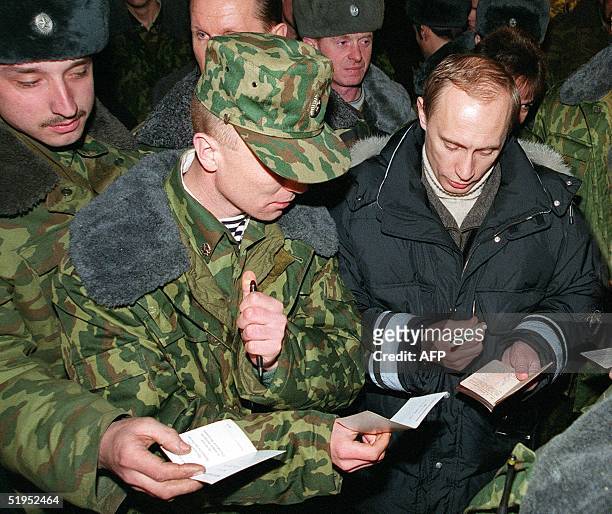 Acting Russian President Vladimir Putin signs autographs to Russian soldiers after an awarding ceremony in Gudermes, 30 kms east of Grozny on...