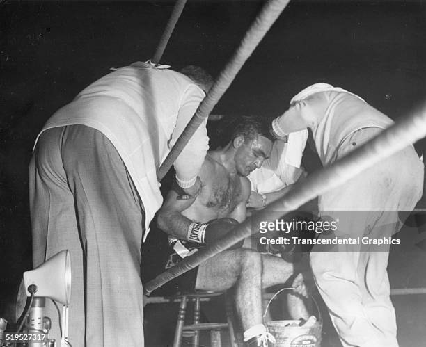 View of American middleweight boxer Carmen Basilio as he sits between his cornermen during a bout, New York, New York, September 1959.