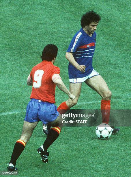 French team captain and midfielder Michel Platini dribbles past Spanish forward Carlos Alonso 27 June 1984 at the Parc des princes in Paris during...