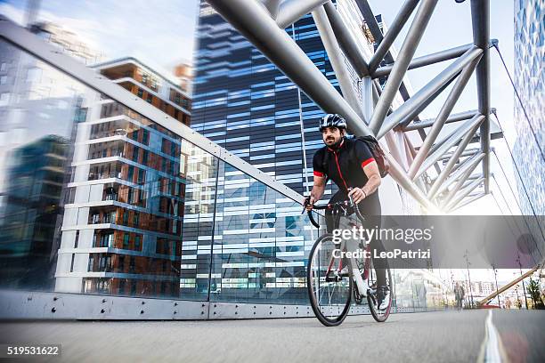 commuter cycling fast at work in the morning - commuter stock pictures, royalty-free photos & images