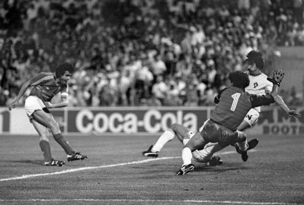 French captain and midfielder Michel Platini scores the winning goal in extra time as Portuguese goalkeeper Bento and defender Frasco dive in vain...