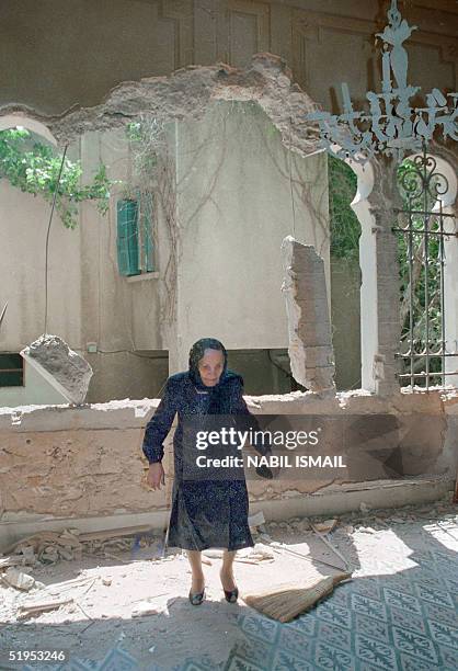 An old Lebanese woman inspects 09 May 1989 the damages in her house in Moslem west Beirut during a break in the fighting between Syrian troops, Amal...