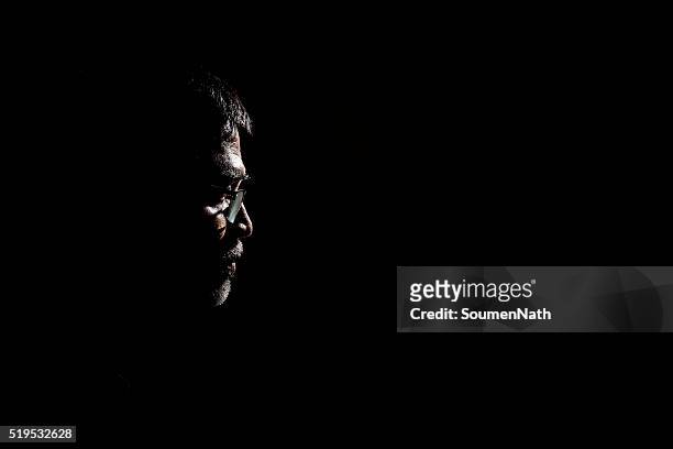 portrait of a senior man in dark background. - black background portrait stockfoto's en -beelden