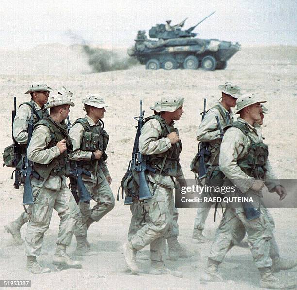 Marines from the 15th Marine Expeditionary Unit walk through the desert during military exercises codenamed "Eager Mace" at the Udairi Range in the...