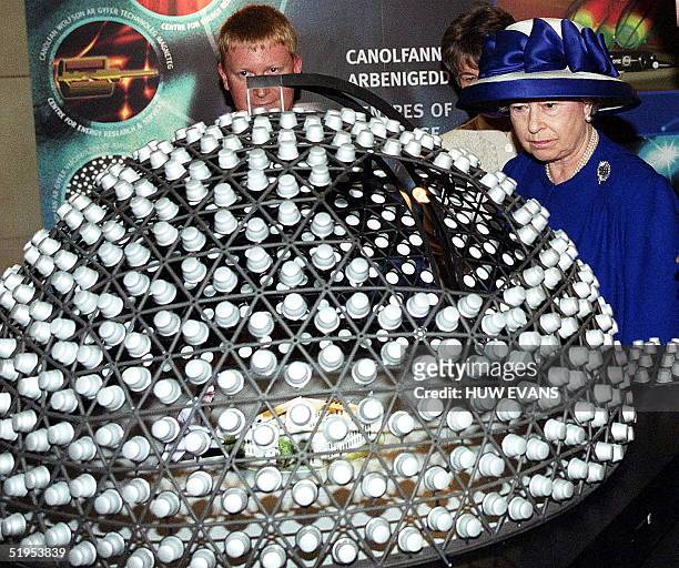 Britain's Queen Elizabeth II studies a model of SkyDome produced by the Welsh School of Architecture while on a visit to Cardiff University to see...