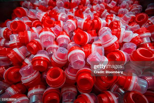 Red bottle pouring spouts sit in a bin on the Persil color gel laundry detergent production line inside the Henkel AG factory in Duesseldorf,...