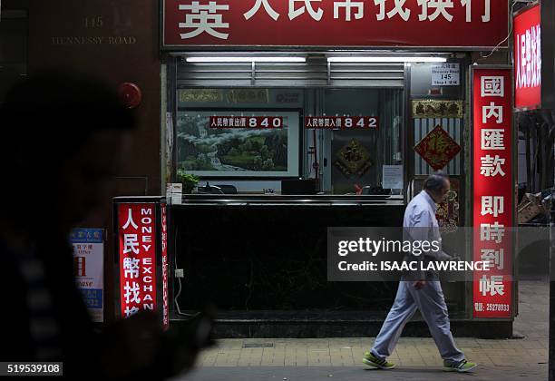 Pedestrians walk past a money exchange business in the Wan Chai district of Hong Kong on April 7, 2016. The Panama Papers leak has put the spotlight...