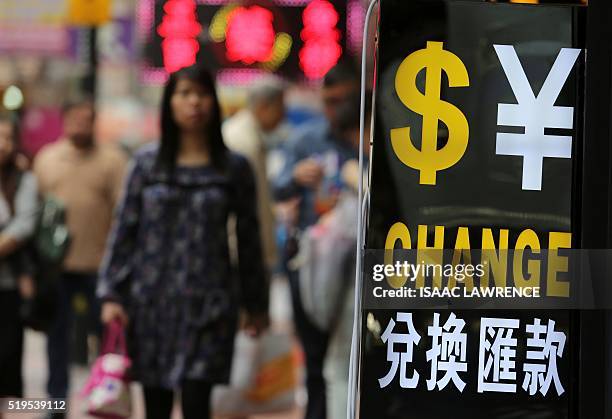 Pedestrians walk past a money exchange business in the Wan Chai district of Hong Kong on April 7, 2016. The Panama Papers leak has put the spotlight...