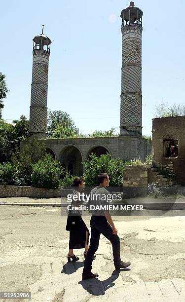 Couple walk 18 June 2000 in front of a mosque in Stepanakert, the capital of the disputed Azerbaijan territory of Nagorny-Karabakh. Voters elected 18...