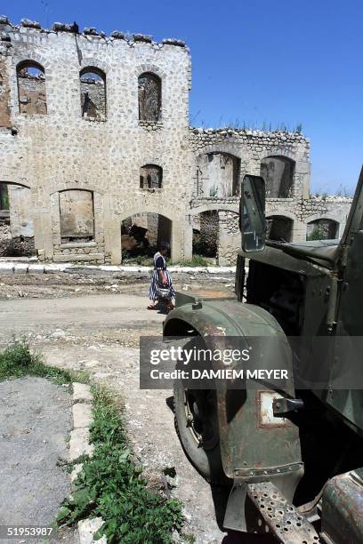 Woman walk 17 June 2000 in front of a devastated building in Shushi, the a small town of the disputed Azerbaijan territory of Nagorno-Karabakh....